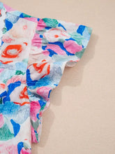 Floral print tie v neck blouse with vibrant ruffled short sleeves featuring bold pink blue and orange blooms on white
