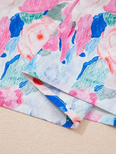 Floral print tie v neck blouse with ruffle short sleeves in pink blue and green hues on white background