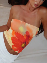A vibrant orange and red floral print tube top with a yellow center made of stretchy fabric