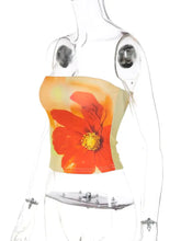 A vibrant orange floral print tube top with yellow center displayed on a transparent mannequin