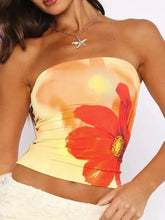 A vibrant orange and yellow floral print tube top with a large red poppy flower print and golden center