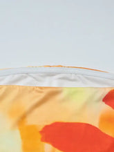 Floral print tube top featuring vibrant orange and yellow tie-dye fabric with a white zipper along the top edge