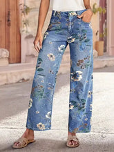 Blue denim floral print wide leg jeans featuring vibrant white and green blossoms for stylish casual wear