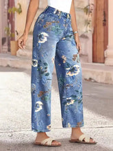 Blue denim floral print wide leg jeans with white brown and green blossoms showcasing a wide leg cut