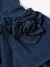 A dark blue floral ruffle layered denim dress with a detailed denim fabric flower appliqué and visible stitching