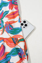 White iPhone 13 Pro on floral ruffled strap V-neck maxi dress