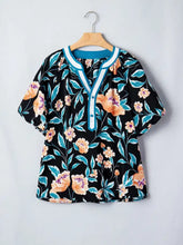 Black floral short bubble sleeve blouse with orange and teal blossoms and turquoise notched neck trim