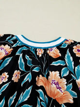 Black floral short bubble sleeve blouse with notched neck featuring orange blossoms teal leaves and white collar trim