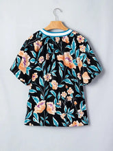 Black floral short bubble sleeve blouse with peach and teal blossoms and white-trimmed notched neck detail