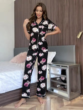 Black floral short sleeve shirt and pants lounge set with pink and white rose pattern and contrasting white piping