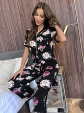 Black floral short sleeve shirt and pants lounge set with pink and white roses accented by white piping on collar and cuffs
