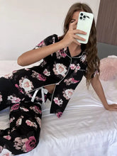 Floral short sleeve shirt and pants lounge set in black with pink and white floral pattern and white piping trim