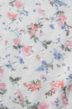 A delicate white lace floral textured square neck sleeveless bodysuit with soft pink blue and green patterns