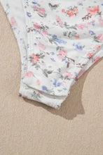 White floral patterned bikini bottom with pink blue gray blossoms complements floral textured square neck bodysuit