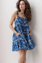Blue floral print denim dress with tiered square neck and white lace trim along ruffles and pockets