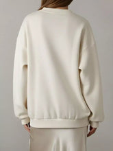 Cream-colored flower dropped shoulder sweatshirt with oversized relaxed fit and ribbed cuffs