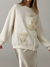Cream-colored flower dropped shoulder sweatshirt with 3d tulip appliqués and a drawstring pocket
