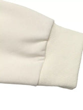 Cream-colored ribbed knit cuff on a soft cotton flower dropped shoulder sweatshirt sleeve with dropped shoulder design
