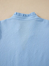Light blue waffle-knit textured blouse with ruffled collar featuring flower embroidered puff sleeves and split neck design