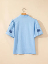 Light blue textured blouse with flower embroidered puff sleeves and a split neck for elegant casual wear