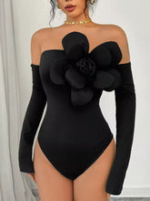 Black off-the-shoulder long sleeve bodysuit with three-dimensional floral embellishment on the chest