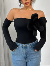 Black off-shoulder long sleeve bodysuit with large floral embellishment on shoulder designed as a shoulder long sleeve garment