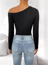 Black flower one shoulder long sleeve bodysuit with elasticized neckline and fitted silhouette shoulder long sleeve top