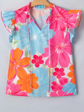 A flower printed sleeveless blouse with neck ruffle trim featuring pink, blue, and orange flowers on white fabric