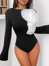 Black long sleeve bodysuit with flower round neck and large white sheer ruffled floral accent on the shoulder