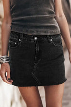 Black denim mini skirt with frayed hem and silver-toned hardware highlighting the front design details