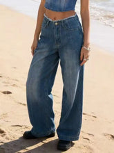 High-waisted wide leg denim jeans in medium blue wash with frayed hem and classic button fly for casual wear
