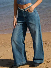 High-waisted blue denim jeans with a wide leg cut and frayed hem for a stylish casual look