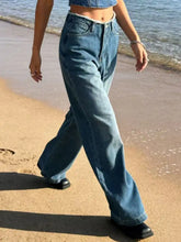 High-waisted medium-blue denim frayed hem wide leg jeans with a classic five-pocket design and raw hem detail