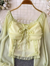 A delicate pale green sheer frill flounce sleeve blouse with ruffled sleeves and front tie detail