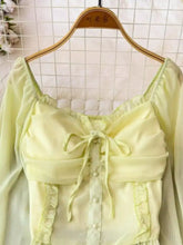 Pale yellow long-sleeved frill flounce sleeve blouse with square neckline and ruffled details in lightweight fabric