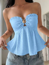 Light blue frill tube top with textured fabric, ruffled neckline, and central gold-toned circular buckle detail