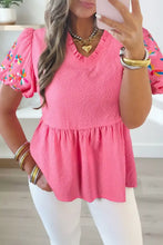 Pink textured blouse with neck flower embroidered puff sleeves and a flared hem for elegant style