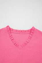 A vibrant pink textured blouse with frilled v neck and delicate neck flower embroidered puff sleeves