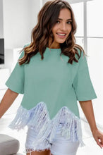 Woman in fringe round neck short sleeve mint green T-shirt and white shorts