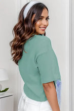 Woman in fringe round neck short sleeve t-shirt with wavy brown hair