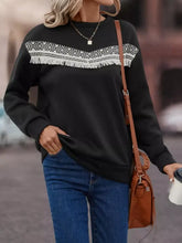 Black long-sleeved crew neck sweatshirt with white geometric fringe trim and machine wash care instructions
