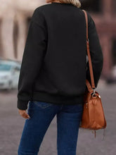 Brown leather crossbody bag with front zipper and tassel detail shown alongside crew neck fringe trim sweatshirt care instructions