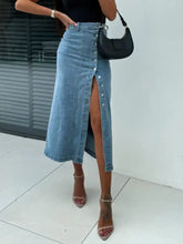 Light-wash midi denim skirt with front button closure and high slit featuring a stylish button slit design