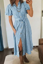 Light blue denim dress with short bubble sleeves, buttons collared short front, and tied waist belt