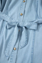 Light blue denim dress with gold-tone buttons collared short bubble sleeves and self-tie belt full buttons long denim dress