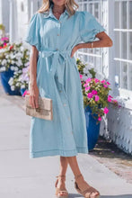 Light blue denim dress with full buttons collared short bubble sleeves and a belted waist midi length