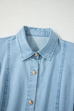 Light blue denim dress with a classic collar, gold-toned buttons, and short bubble sleeves in a full buttons collared short style