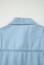 Light blue denim dress with full buttons collared short bubble sleeves and visible stitching in classic style