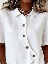 Full size casual asymmetrical white short-sleeved button shirt with brown buttons and subtle textured fabric