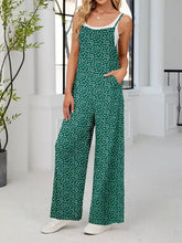Green floral print wide-leg overalls with white trim and thin straps